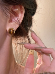Macro detail of oval tiger eye stone earrings with 18k gold plated vintage finish
