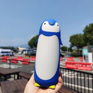 Macro view of blue penguin cartoon vacuum insulated stainless steel water bottle outdoor