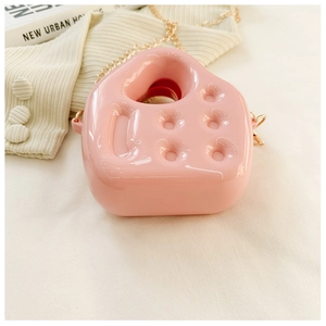 Detail view of pink PVC jelly bag with unique cheese shape and gold chain strap