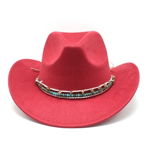 Détail d'un chapeau de cowboy rouge en suède avec perles ethniques et bord incurvé