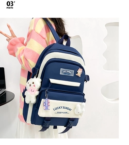 Rear view of navy blue and beige backpack with Lucky Sunday logo and bear charm