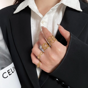 Detail of four gold hollow heart and pig nose chain rings on a female model hand