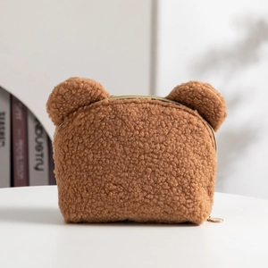 Detail of soft brown teddy fleece makeup bag featuring cute bear ears and gold zipper