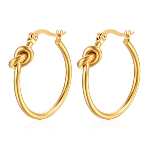 Detail of elegant gold knotted hoop earrings in polished stainless steel for women
