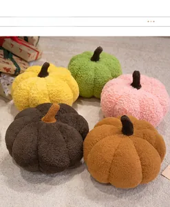 Five assorted colors of plush pumpkin pillows on a cozy rug in a home setting