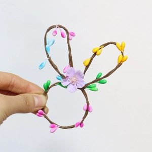 Macro detail of handmade Easter bunny ear napkin ring with colorful beads and floral decor