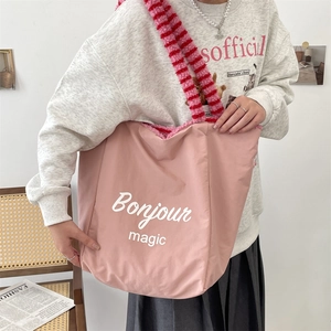 Pink canvas tote bag featuring fuzzy striped handles and Bonjour graphic print