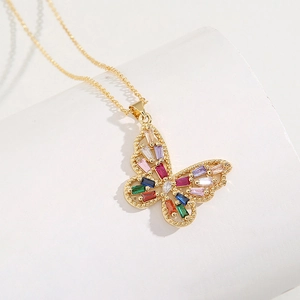 Détail du pendentif papillon doré avec pierres précieuses colorées et chaîne