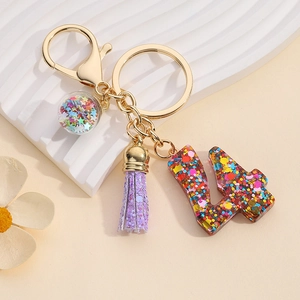 Detail view of resin number 4 keychain with colorful sequins and purple tassel