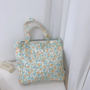 Detail of floral canvas tote bag featuring orange flowers and simple wish fabric label