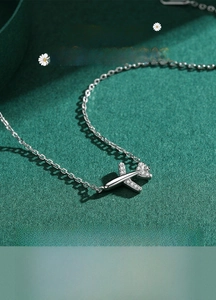 Macro shot of silver airplane pendant with micro-pave cubic zirconia on wings