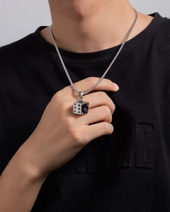 Close-up of a man wearing a silver stainless steel dice pendant necklace on a black T-shirt