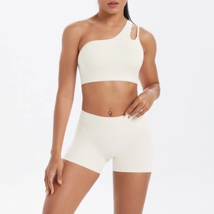 Detail view of cream white one-shoulder sports bra and high-waisted yoga shorts set