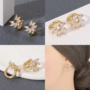 Detalle macro de pendientes de aro florales bañados en oro 18K con circonitas blancas