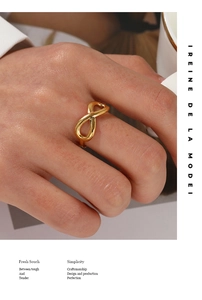 Detailed view of infinity symbol gold ring worn on finger with elegant aesthetic