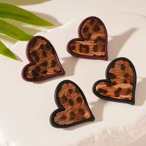 Boucles d'oreilles cœur léopard rétro avec bordures noires et rouges sur marbre
