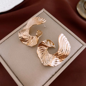 Detailed macro view of gold geometric earrings with elegant textured metallic stripes