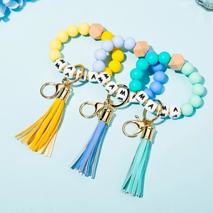 Detail of silicone bead wristlet keychains with tassels and white MAMA letter beads