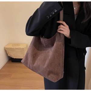 Brown faux suede tote bag shown on model with spacious design for daily outfits