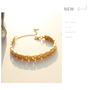 Detail of gold watchband link bracelet with polished finish and lobster clasp
