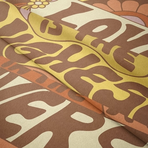 Close-up of 70s retro style tapestry fabric showing Stay Cheery text and soft velvet texture