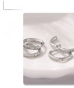 Close-up of silver-colored titanium steel hoop earrings featuring pave-set cubic zirconia