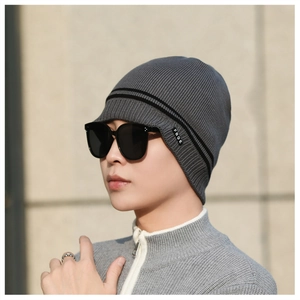 Detail view of winter knitted beanie featuring dark grey ribbed fabric and black FBQE side tag