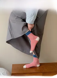 Détail de chaussettes en coton à rayures rouges et blanches avec revers bleu marine