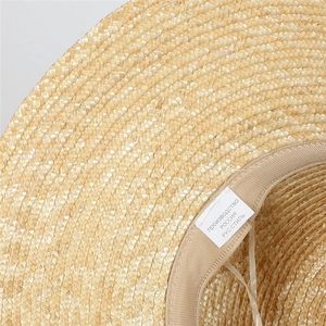 Detail shot of natural straw hat texture with inner sweatband and brand labels