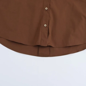 Detail of dark brown poplin shirt featuring wooden buttons and a curved hemline