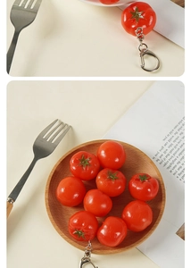 Macro detail of artificial cherry tomato keychain with realistic texture and silver lobster clasp