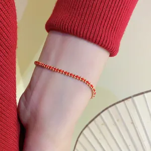 Handwoven red rope bracelet with gold beads and a minimalist festive New Year design