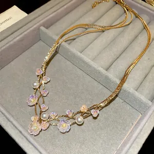 Elegant gold double-layer necklace featuring pearlescent flowers and white pearls