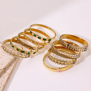 Stack of 18k gold plated stainless steel bangles with colorful gemstones and cutouts
