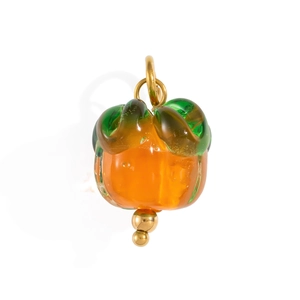 Detailed view of orange glass persimmon pendant with golden metal leaf accents