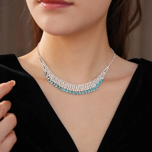 Detail of silver multi-row rhinestone fringe necklace with blue crystals on model