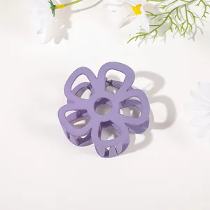 Detailed top view of matte purple flower hair claw clip on clean background