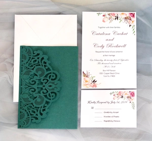 Detail view of green laser-cut wedding invitation set with floral cards and white envelope