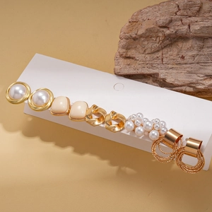 Close-up of 10-piece pearl and resin flower stud earring set on white display card