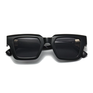 Detail view of bold square black sunglasses with thick frames and premium metal hinges