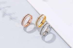 Detailed close-up showing gold, rose gold, and silver rings with inlaid zircons