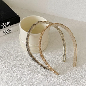 Close-up of sparkling crystal beaded slim headbands in grey and champagne gold colors