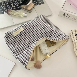Détail de la trousse de maquillage à damier avec cœur et accessoires dans un décor