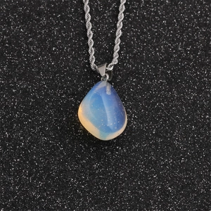 Irregular moonstone drop pendant necklace with silver twisted chain on black background