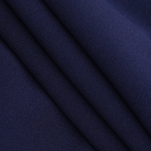 Macro texture of navy blue cross-knot dress fabric showing soft drape and fine weave