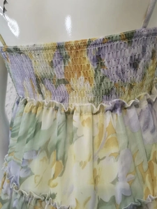 Detail of floral chiffon dress with elastic smocked bodice and vibrant yellow print