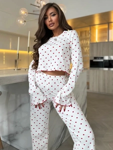 Detail of flared cuffs with red lettuce trim on heart-printed white knit pajama set