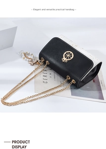 Detail of contrast crossbody bag with golden crown emblem and pearl bow pendant