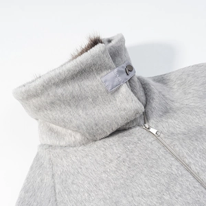 Gros plan d'un manteau en peluche gris clair avec col montant et fermeture éclair