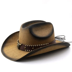 Vintage straw cowboy hat with a metal bull head emblem and studded leather band